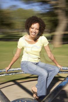 Young Woman Riding On Roundabout In Park