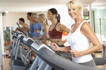 Senior Woman On Running Machine In Gym