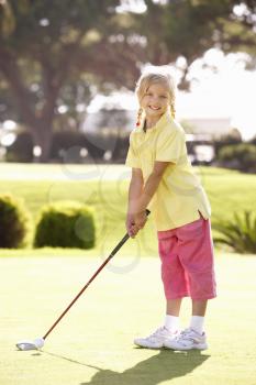 Young Girl Practising Golf On Putting On Green