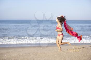 Young woman running on beach