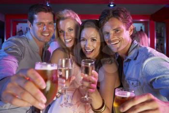 Group Of Young People Having Fun In Busy Bar