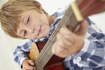 Young boy playing acoustic guitar