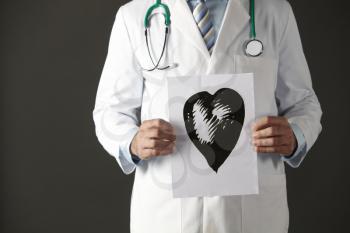 American doctor holding ink drawing of heart