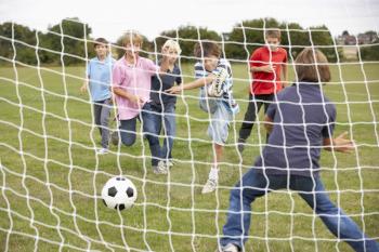 Boys playing soccer in park