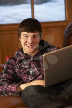 Teenage Boy Relaxing On Sofa With Laptop