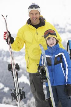 Father And Son On Ski Holiday In Mountains