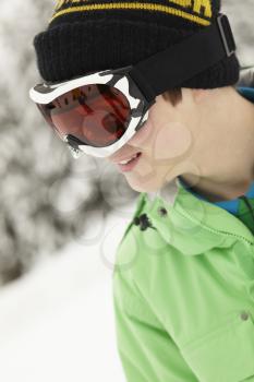 Teenage Boy Wearing Ski Goggles On Ski Holiday In Mountains