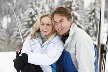 Middle Aged Couple On Ski Holiday In Mountains