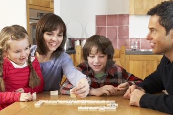 Family Playing Dominoes In Kitchen