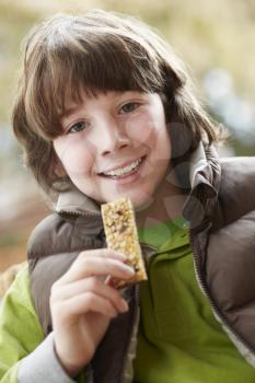 Boy Eating Healthy Snack Bar Wearing Winter Clothes
