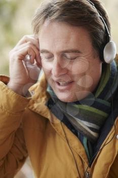 Man Wearing Headphones And Listening To Music Wearing Winter Clothes