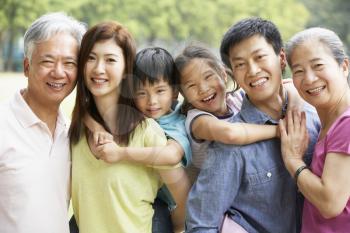 Portrait Of Multi-Generation Chinese Family Relaxing In Park Together