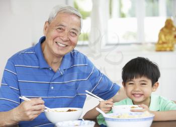 Portrait Of Chinese Grandfather And Grandson Eating Meal Together