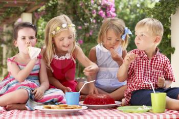 Group Of Children Eating Jelly At Outdoor Tea Party