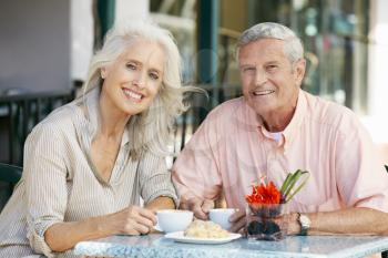 Senior Couple Enjoying Snack At Outdoor Caf