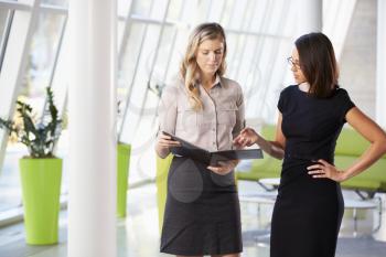 Two Businesswomen Having Informal Meeting In Modern Office