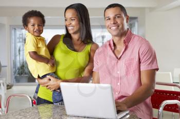 Family Using Laptop In Kitchen Together
