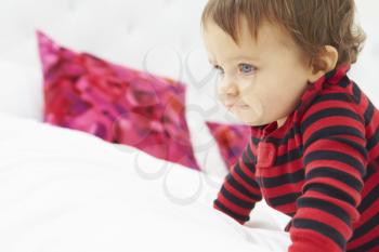 Toddler Crawling On Bed Wearing Pajamas