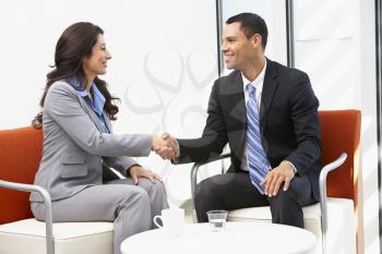 Businessman And Businesswoman Shaking Hands After Meeting