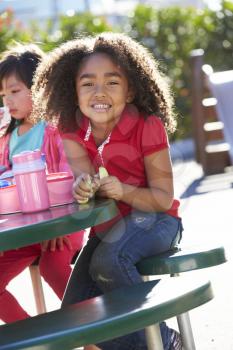 Elementary Pupil Sitting At Table Eating Lunch