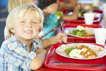 Elementary Pupils Enjoying Healthy Lunch In Cafeteria