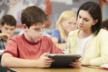 Pupils In Class Using Digital Tablet With Teacher