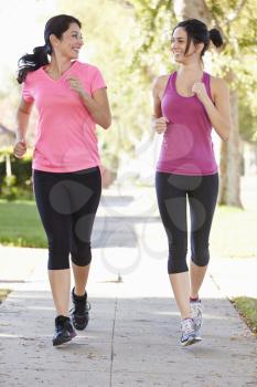 Two Female Runners Exercising On Suburban Street