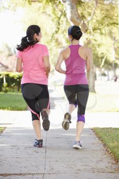 Rear View Of Two Female Runners On Suburban Street