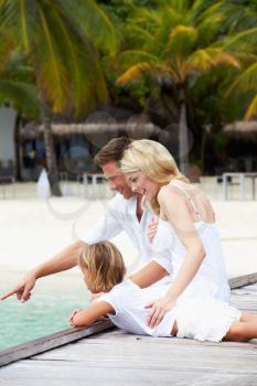 Family Sitting On Wooden Jetty