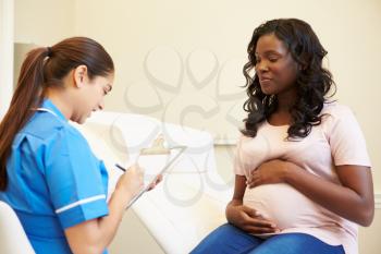 Pregnant Woman Being Given Ante Natal Check By Nurse