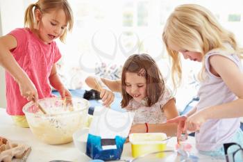 Three Girls Making Cupcakes In Kitchen