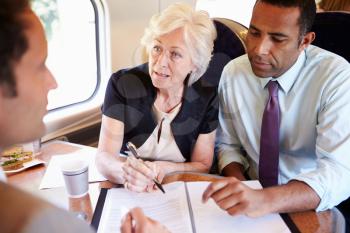 Group Of Businesspeople Having Meeting On Train