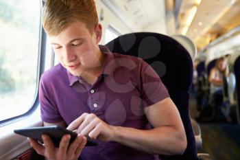 Young Man Reading E Book On Train Journey