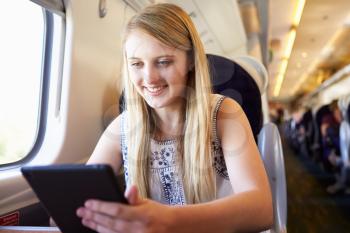 Teenage Girl Using Digital Tablet On Train Journey