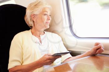 Senior Woman Reading E Book On Train Journey