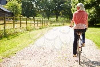 Middle Aged Woman Enjoying Country Cycle Ride