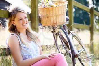 Teenage Girl Relaxing On Cycle Ride In Countryside