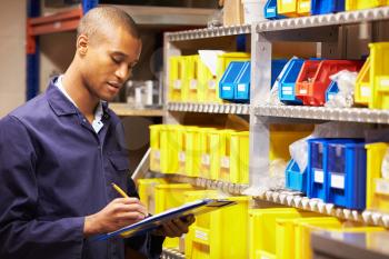 Worker Checking Stock Levels In Store Room