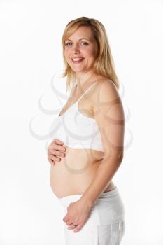 Studio Portrait Of 4 months Pregnant Woman Wearing White