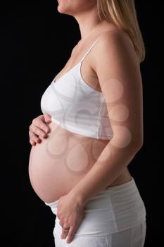 Close Up Portrait Of 5 months Pregnant Woman On Black Background