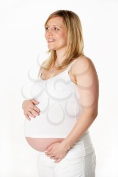 Studio Portrait Of 7 months Pregnant Woman Wearing White