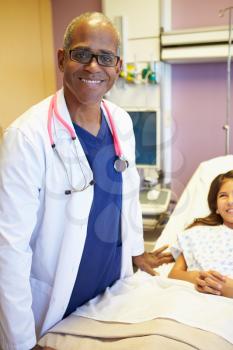 Young Girl Talking To Male Doctor In Hospital Room