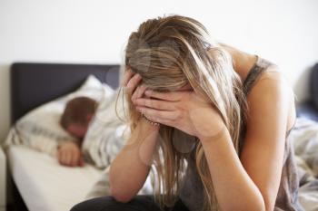 Worried Teenage Girl In Bedroom With Boyfriend