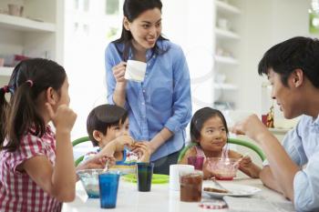 Asian Family Having Breakfast Together In Kitchen