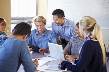 High School Students With Teacher In Class Using Laptops