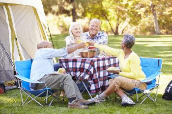 Two Senior Couples Enjoying Camping Holiday In Countryside