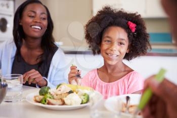 Mother And Daughter Having Family Meal At Table