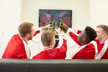 Group Of Sports Fans Watching Game On TV At Home