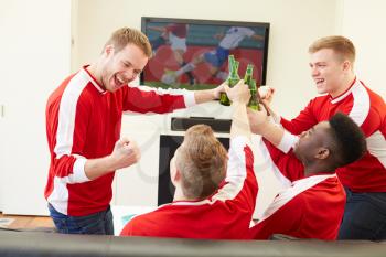 Group Of Sports Fans Watching Game On TV At Home