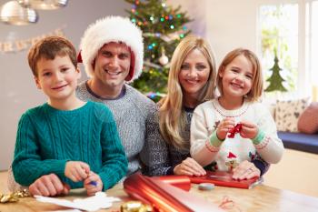 Family Wrapping Christmas Gifts At Home